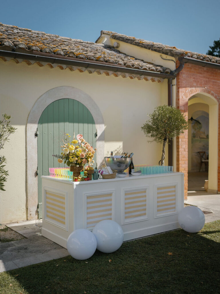 Outdoor bar setup with pastel accents and florals during a Provence wedding weekend.