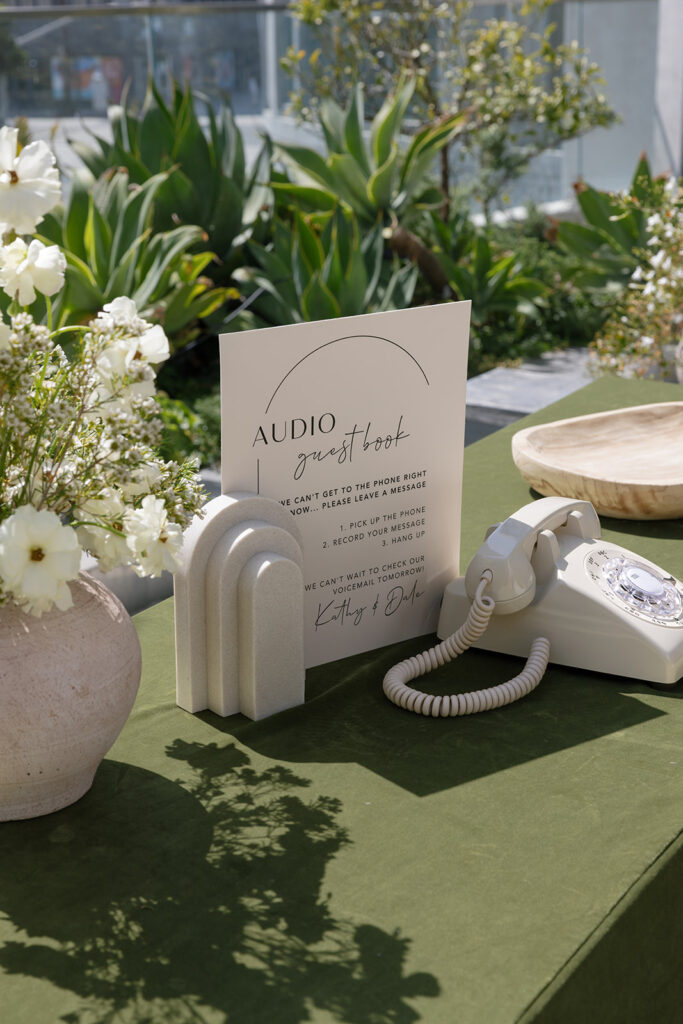 Outdoor wedding detail featuring an audio guestbook styled with minimalist elements as part of a refined wedding design process.