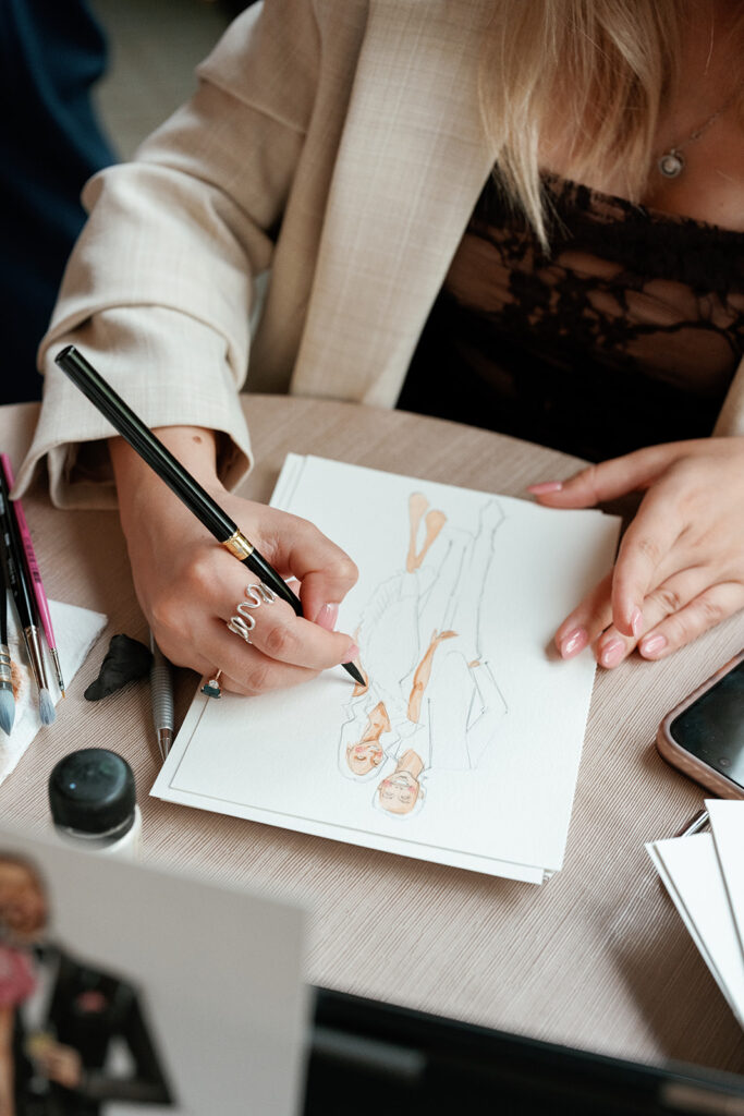 Close-up of a guest sketching a fashion illustration, highlighting interactive wedding guest experience ideas.