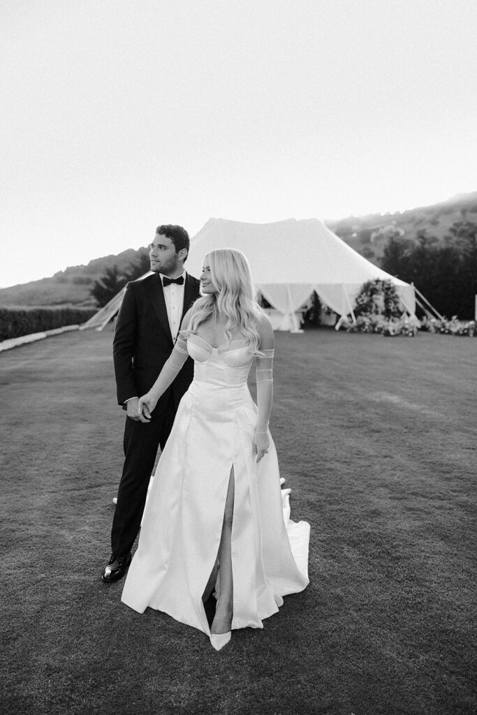 Bride and groom standing together on a lawn in formal attire during a California destination wedding weekend.