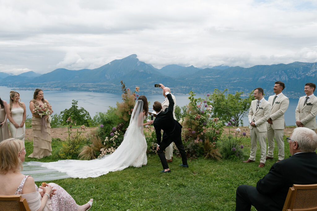 Bride and groom pausing for a photo with guests nearby, emphasizing relaxed moments that help create a memorable wedding experience.