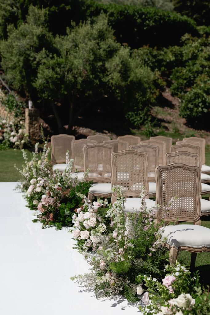 Outdoor wedding ceremony seating with floral-lined aisle, highlighting thoughtful design for a California destination wedding.