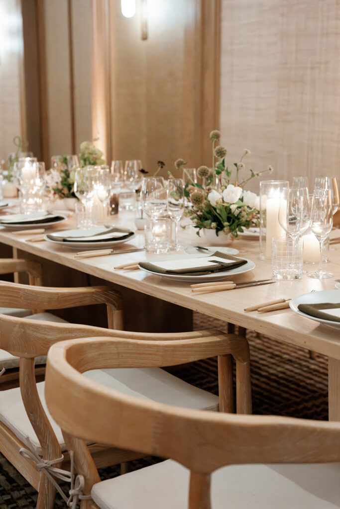 Long wedding reception table with curated place settings, glassware, and florals, reflecting detailed planning and tablescape design.