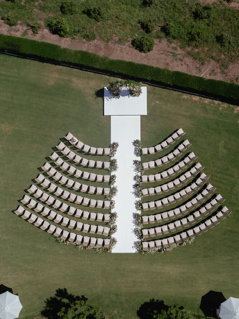 Aerial view of outdoor Santa Barbara wedding ceremony layout with curved seating and aisle