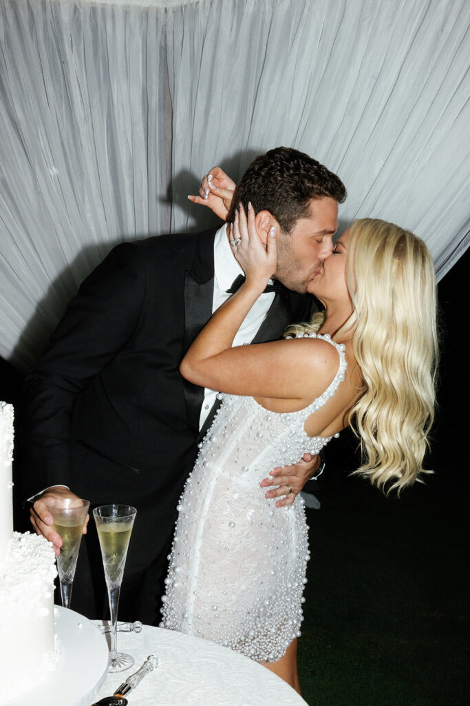 Bride and groom sharing a champagne moment during the reception, captured in an intimate black and white portrait.