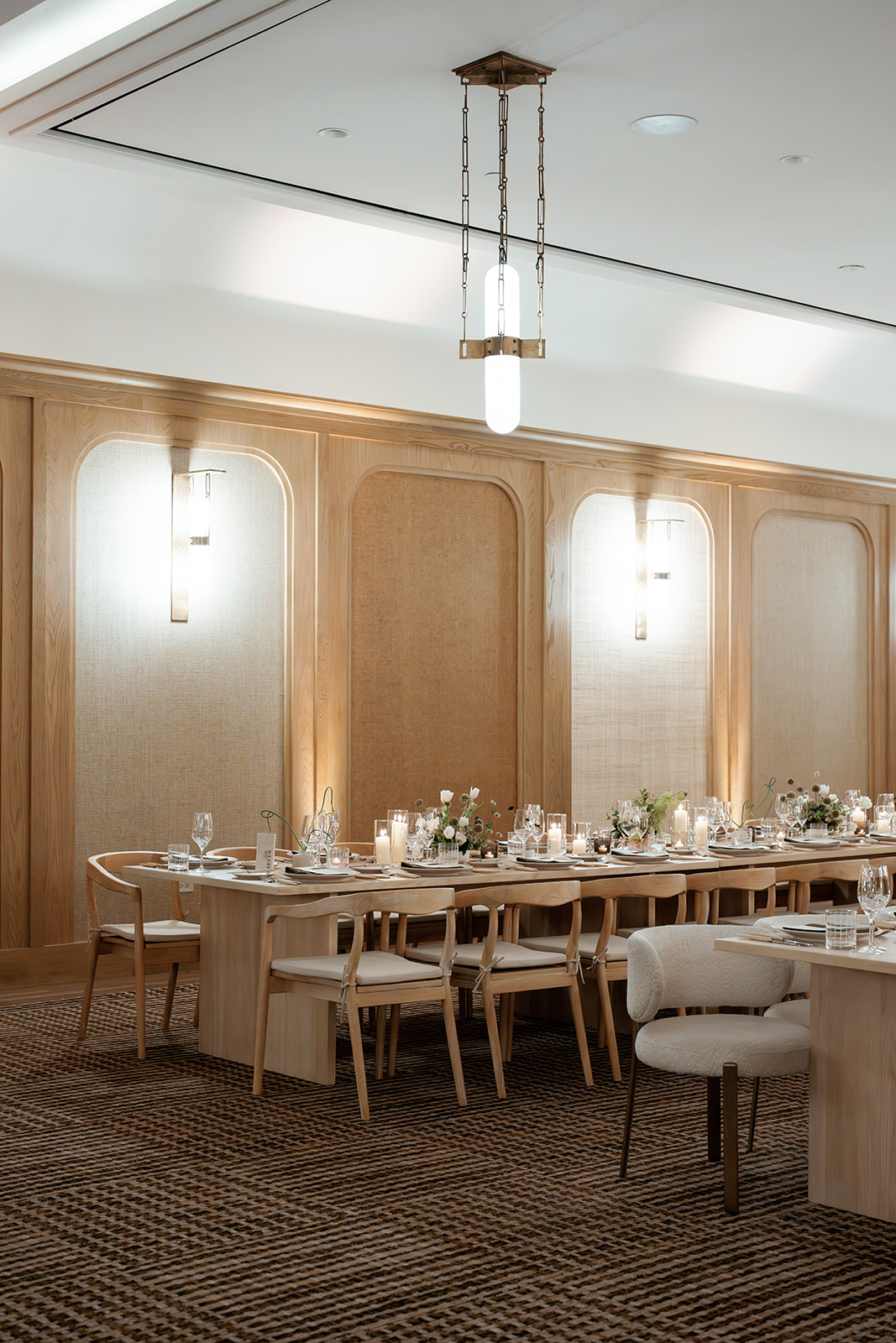 Elegant wedding reception with custom tables, wood chairs, candlelight, and refined design reflecting what couples receive with full service wedding planning.