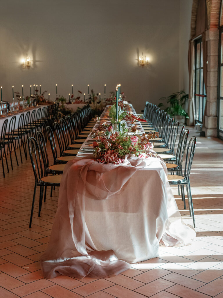 Elegant indoor reception setup with layered linens, floral centerpieces, and candlelight designed for a memorable wedding guest experience.