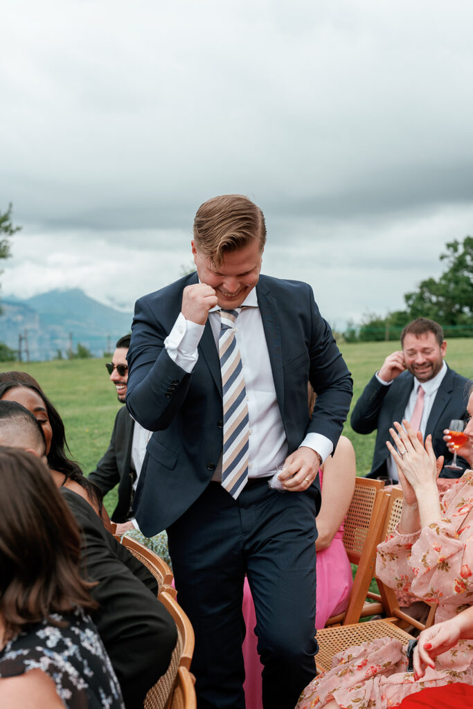 A wedding guest laughs freely outdoors during an unplugged ceremony, fully present without a phone in hand.