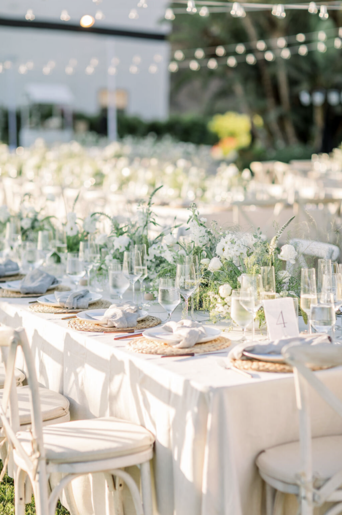 Outdoor wedding reception at a Southern California private estate with string lights, long dining tables, and lush garden setting