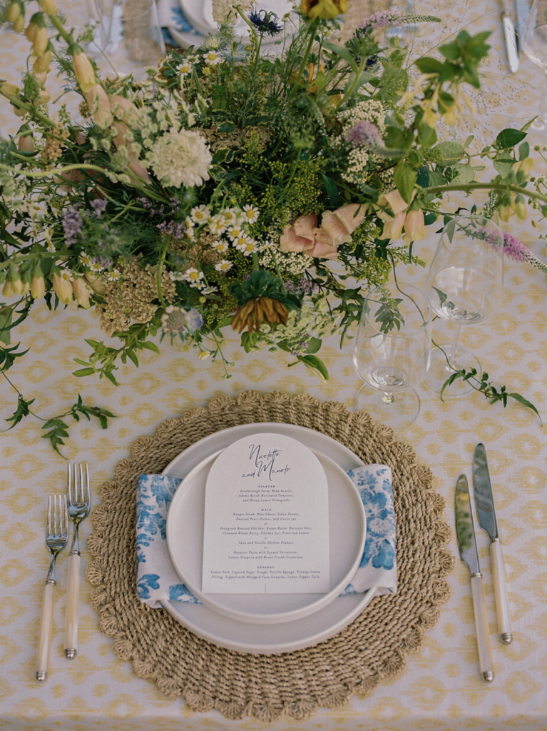 Overhead floral centerpiece with yellow and white blooms above a place setting at a California destination wedding reception